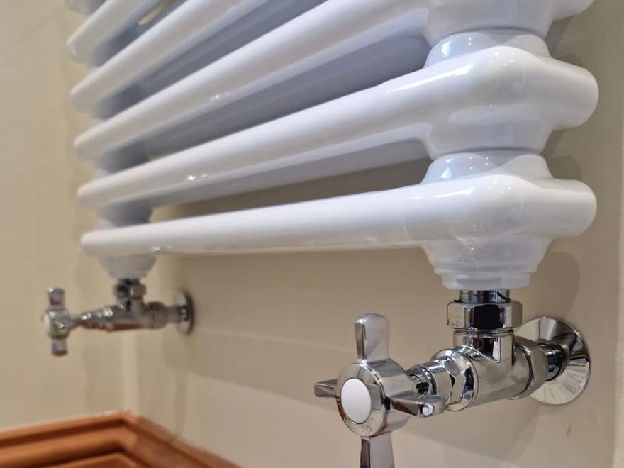White column radiator with chrome crosshead valves installed by Lloyd